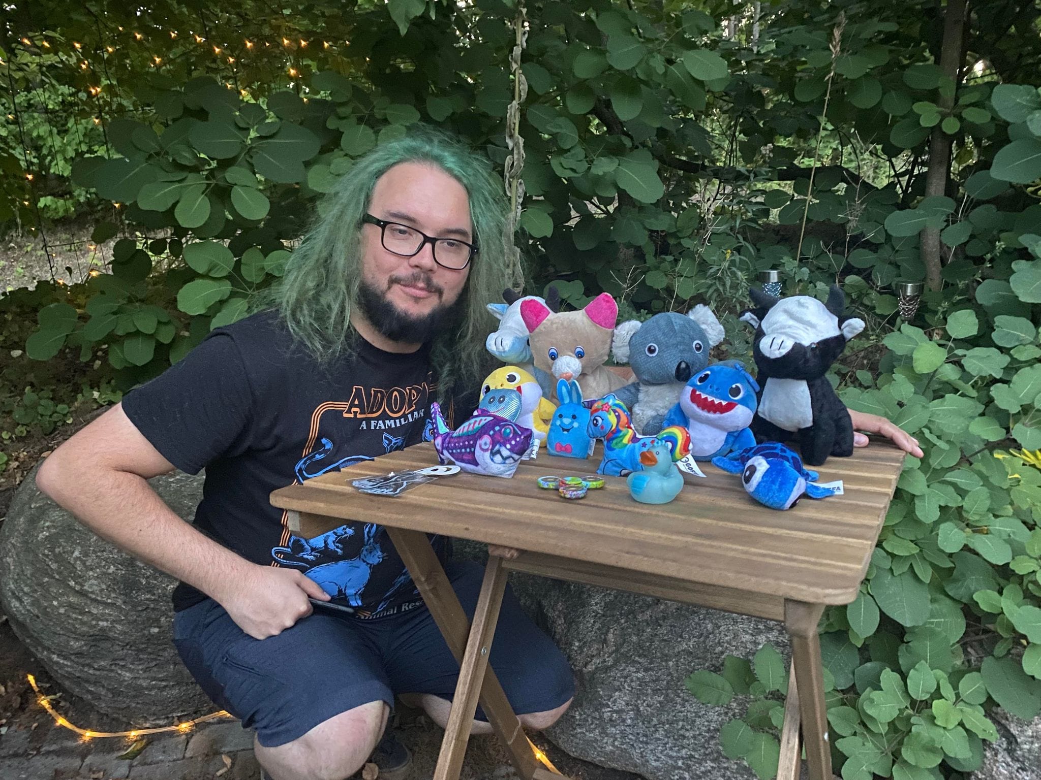 A man with green hair shows off his prizes from the arcade